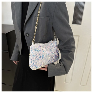 Detailed view of iridescent white sequins and gold metal chain on a fashion evening bag
