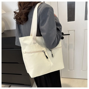 Détails du sac cabas en toile avec doubles poches zippées devant et anses tissées solides