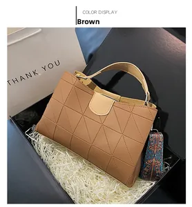 Close-up of brown geometric quilted bucket bag with colorful ethnic style wide strap