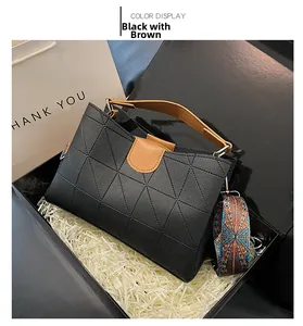 Detail of black and brown bucket bag with geometric patterns and colorful woven strap