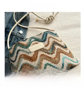 Close-up of contrast wave knit wool pattern and leather logo label on bucket bag
