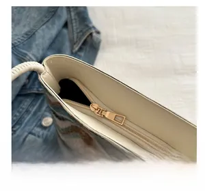 Close-up of golden metal zipper on striped woven bucket bag with cream leather trim