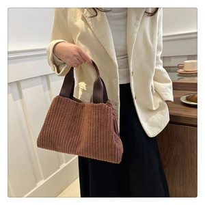 Close-up of brown corduroy tote bag with textured stripes and thick webbing handle