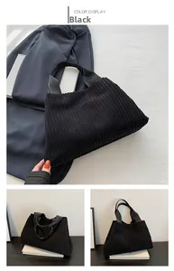 Detail view of black corduroy tote bag showing soft ribbed texture and fabric handles