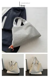 Detailed view of grey corduroy bucket bag with vertical texture and wide straps