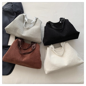 Flat lay of corduroy tote bags in four colors with striped texture and fabric handles