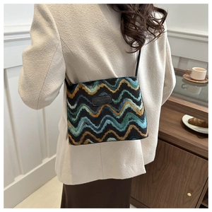 Detailed back view of a retro multicolor wavy knit bucket bag worn by a model