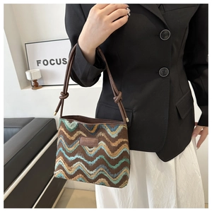 Detail of knit pattern bucket bag with wave texture and brown leather branding