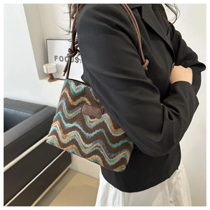 Detail of vintage wavy pattern knit shoulder bag with leather logo patch and knot strap