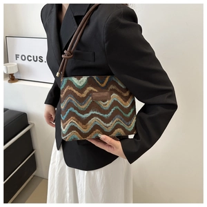 Detail of retro zigzag patterned wool bucket bag with leather strap and logo patch