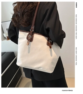 Detail of minimalist tote bag with off-white canvas and dark brown leather straps