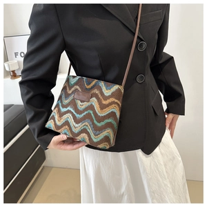 Close-up of wool plaid bucket bag with wavy pattern and leather brand patch detailing
