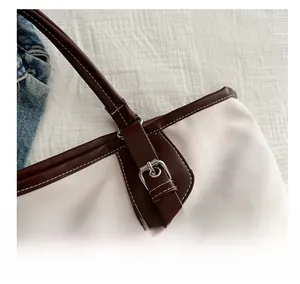 Detail showing contrast stitching and premium leather strap on canvas tote bag