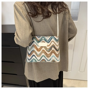 Chic multi-color wavy knit bucket bag with contrast stripes and leather patch detail