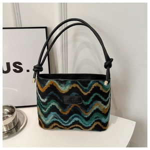 Detail of colorful wavy pattern shoulder bag with black leather handle and logo patch
