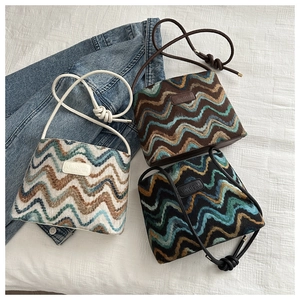Three wavy patterned knit bucket bags in cream, brown, and dark colors with JINGPIN leather patch