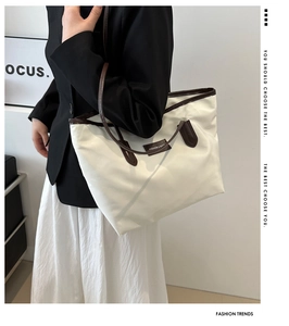 Detailed shot of large beige tote bag with brown straps styled with a casual outfit