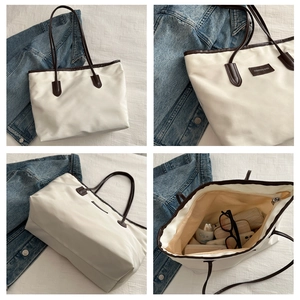 Detail view of large Oxford cloth tote bag showing zip closure and interior storage space