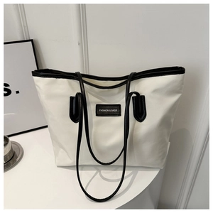 Detail of white nylon tote with black leather trim and Fashion & Bags logo patch