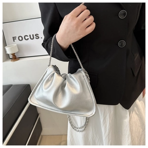 Sac nuage plissé argenté avec chaîne métallique porté par un mannequin en tenue