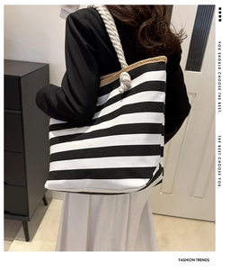 Detail of canvas tote bag featuring nautical rope handles and black striped pattern