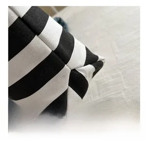 Detailed close-up of stitching and thick canvas texture on a black and white striped tote