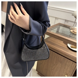 Close-up of sparkling silver rhinestones on a black evening bag with elegant handle