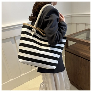 Detail of checkered canvas tote bag with thick rope shoulder strap and woven edge trim