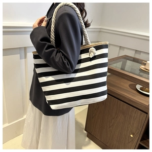 Large capacity striped canvas tote bag with thick rope handles shown on a model