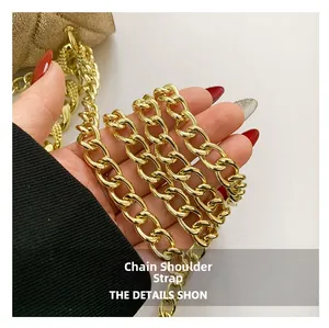 Close-up of golden metal chain strap with polished finish on quilted pearl bag