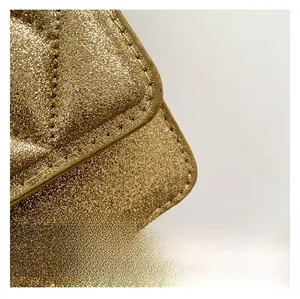 Detailed macro view of high-quality golden glitter quilted fabric and clean stitching
