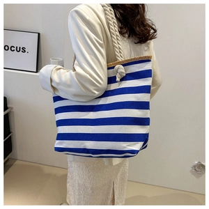 Detail of blue and white striped canvas tote bag with thick nautical rope shoulder straps