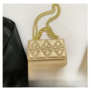 Macro shot of gold sequin quilted square bag with chunky metal chain and glossy texture