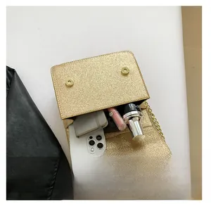 Interior storage view of a gold sequin crossbody bag with chain and dual magnetic buckle
