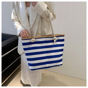 Detail of blue and white striped tote bag with cotton rope handles and woven trim