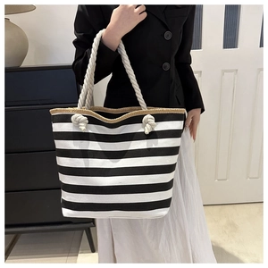 Detail of canvas tote bag showing thick cotton rope handles and black striped pattern