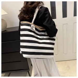 Detail of canvas tote with black and white stripes and white rope shoulder straps