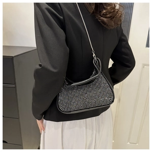 Detailed back view of model wearing a black rhinestone evening bag with silver chain