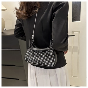 Detail of black crescent hobo bag with silver rhinestones and metal chain strap