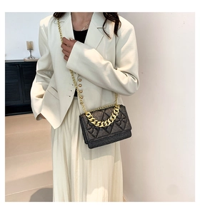 Detail of black glitter quilted bag featuring gold chain strap and elegant texture