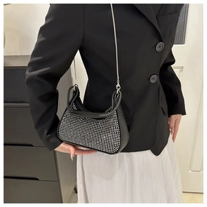 Black crescent bag with silver rhinestones and chain strap worn by a model
