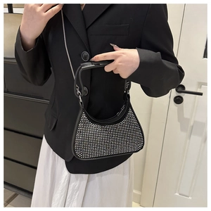 Close-up of a black crescent hobo bag with sparkling silver rhinestones and chain strap