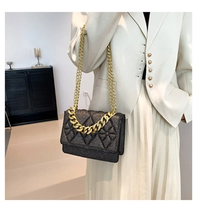 Detail of black sequined crossbody bag with gold chain and diamond quilt texture