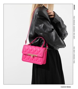 Fashionable rose pink quilted handbag shown as a side view on a model in a black leather jacket