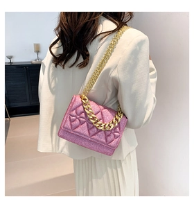 Detailed view of pink quilted chain bag with floral studs and gold-tone metal handle