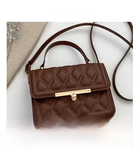 Close-up of brown quilted leather bag featuring a gold twist lock and fine stitching