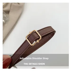 Detail of adjustable dark brown leather shoulder strap with gold metal buckle