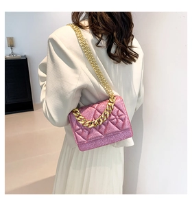 Close-up of pink glitter quilted chain bag with gold decorative accents on white suit