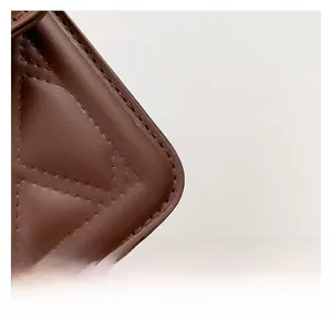 Close-up of brown faux leather handbag showing detailed stone texture and quilting