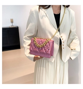 Detail of pink pearl sequin crossbody bag with gold chain strap and bow decoration